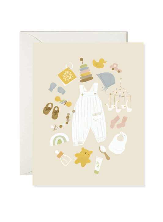 Bébé Things Baby Card by Karen Schipper featuring illustrated newborn essentials including overalls, booties, bib, pacifier, and baby keepsakes on a soft neutral background.