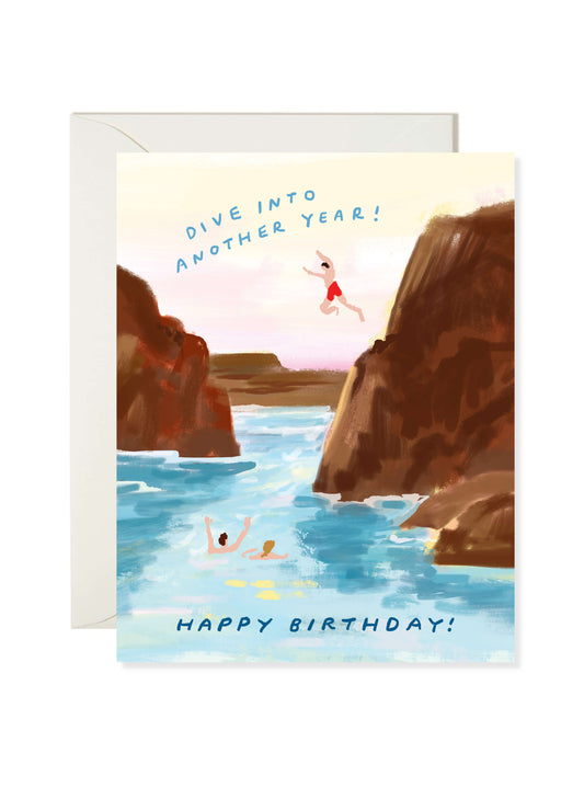 Dive Into Another Year Card by Karen Schipper featuring cliff jumpers diving into blue ocean water between rocky cliffs with a summer birthday message.