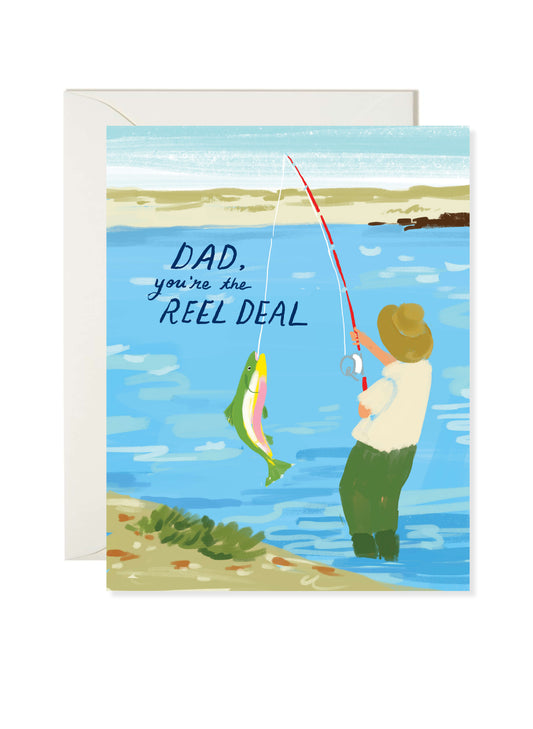 Reel Deal Dad Card by Karen Schipper featuring a dad fishing by a lake with a colorful fish and playful pun message for Father's Day.