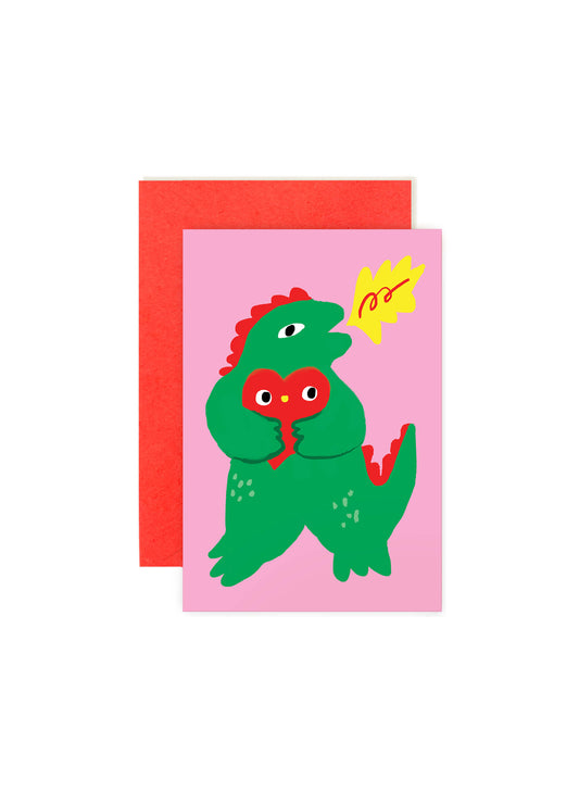 Karen Schipper Kaiju Love mini note card featuring a green monster holding a red heart on a pink background with a red envelope behind it.
