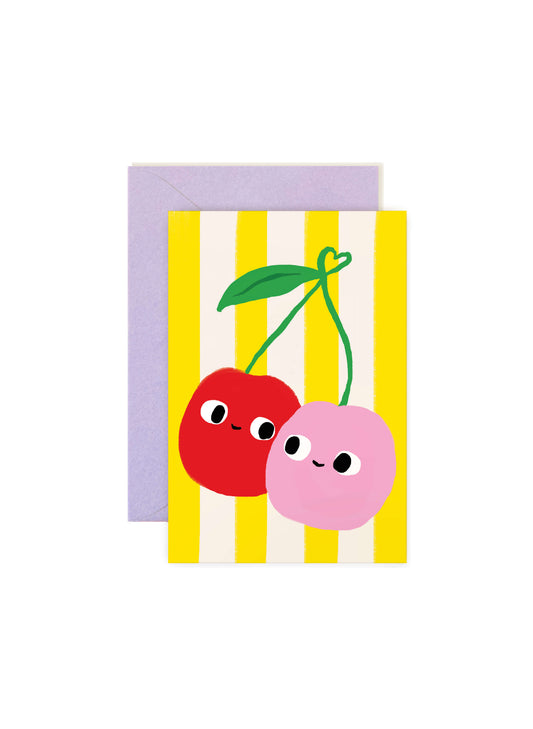 Karen Schipper Cherry Friends mini note card featuring two smiling cherries on a yellow striped background with a lavender envelope behind it.