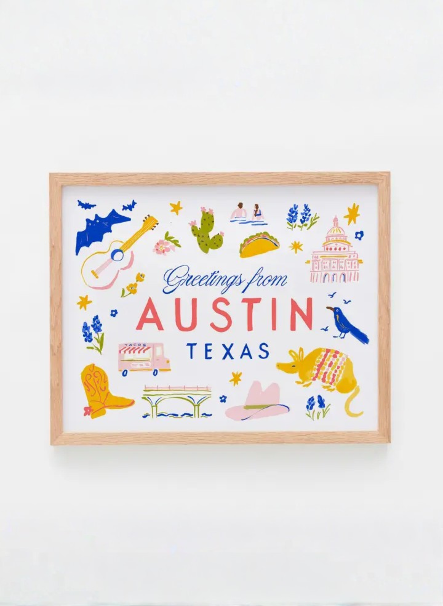 Framed Greetings from Austin Art Print by Karen Schipper featuring colorful Texas icons, Austin landmarks, bluebonnets, bats, and city lettering.