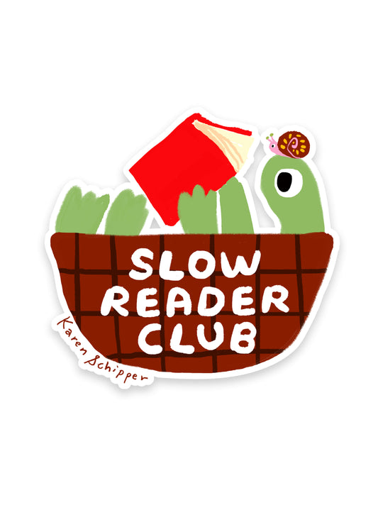Slow Reader Club Sticker by Karen Schipper featuring a green turtle with a red book and a tiny snail above bold “SLOW READER CLUB” lettering on a brown basket of books.