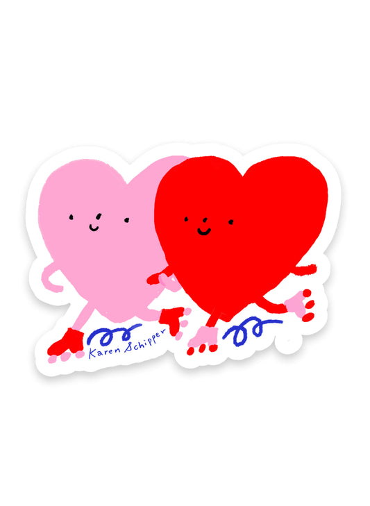 Skating Heart Sticker by Karen Schipper featuring two smiling hearts, one pink and one red, holding hands while wearing skates in a cute illustrated style.
