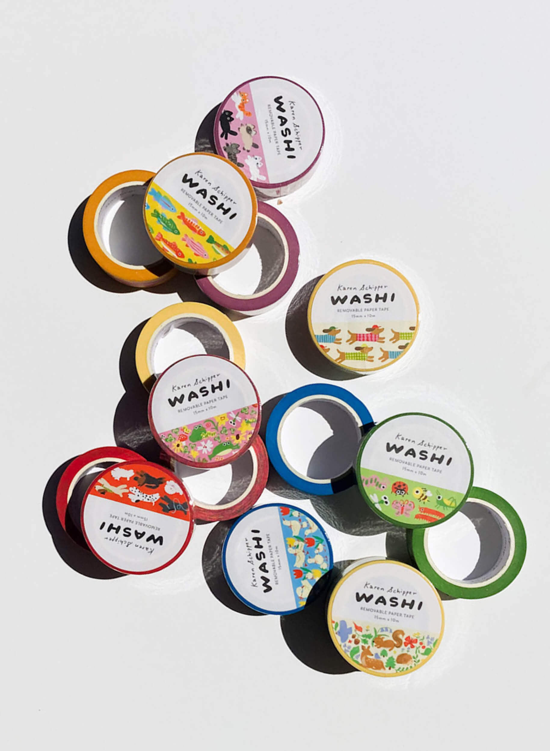 Collection of washi tape rolls with colorful labels on a white background